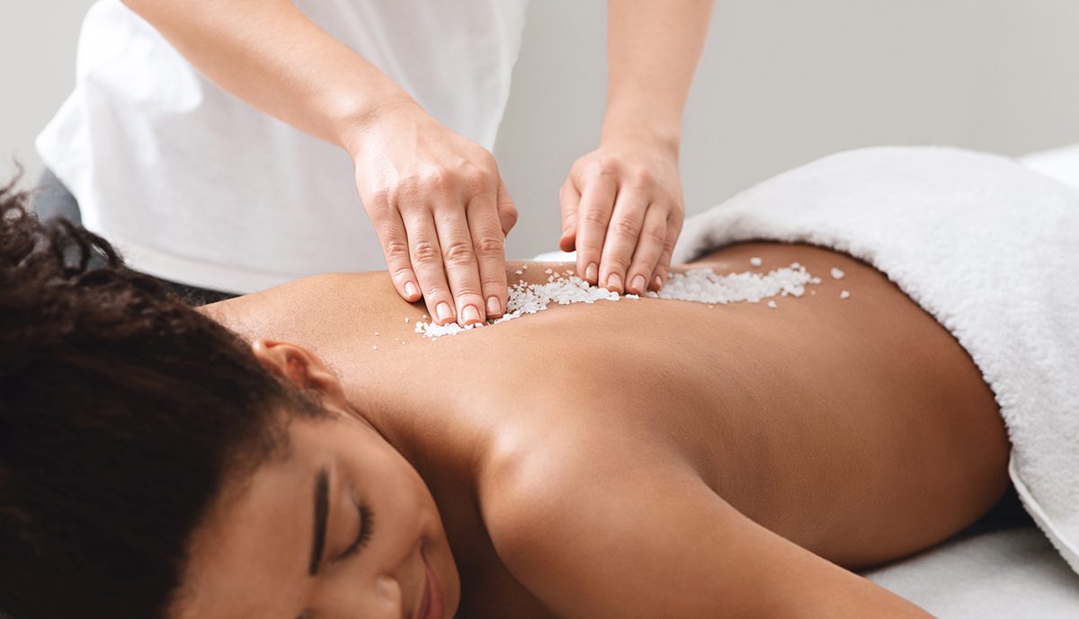 African American Lady Getting Salt Massage At Modern Spa